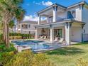 Backyard pool and lounge area offering an outdoor kitchen, sun loungers and lush landscaping at 985 Jack Nicklaus Ct, Kissimmee, FL 34747