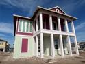 A two-story home under construction shows its framing, which includes white columns and light green and maroon trim at 10025 Dulbecco St, Orlando, FL 32827