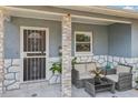 Inviting covered porch with stone accents, outdoor seating, and decorative tile flooring at 1004 Sunwood Lane Ln, Orlando, FL 32807