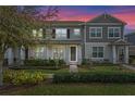 Charming two-story townhome with well-manicured lawn and inviting front porch at dusk at 10358 Spring Arbor Ln, Winter Garden, FL 34787