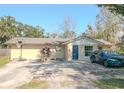 View of single-story home featuring a blue front door and a spacious driveway and an basketball hoop at 1041 Vihlen Rd, Sanford, FL 32771