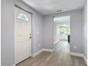 Inviting home entryway featuring light gray paint, white trim and a view of the kitchen with wood-look floors at 1125 E Hubbard Ave, Deland, FL 32724