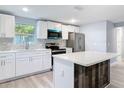 A modern kitchen with white cabinetry, stainless steel appliances, a kitchen island and subway tile backsplash at 1125 E Hubbard Ave, Deland, FL 32724