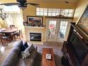 Cozy living room featuring a fireplace, high ceilings, and natural light, creating a warm and inviting space at 1567 Farrindon Cir # 1567, Lake Mary, FL 32746