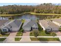 Aerial view of homes showcasing backyard pond and well-maintained landscaping at 17826 Blazing Star Cir, Clermont, FL 34714