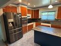 Updated kitchen features stainless steel appliances, wood cabinetry, and center island for modern convenience at 22 Poinsettia Dr, Deland, FL 32724