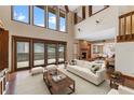 Bright living room with a fireplace, vaulted ceiling, floor-to-ceiling windows, and hardwood floors at 229 Springside Rd, Longwood, FL 32779