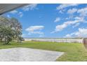 Backyard with a brick patio and a fenced yard overlooking a lake with blue skies at 250 Domino Dr, Orlando, FL 32805