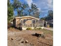 Single-story home with a screened in porch, carport, and mature trees in a partially cleared yard at 31700 Orange St, Sorrento, FL 32776