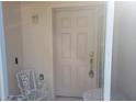 This is a well-lit and inviting entrance to the property, featuring a sturdy door and a comfortable chair at 3567 Capland Ave, Clermont, FL 34711