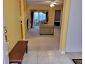 The living room features tile flooring at the entrance, carpet, a ceiling fan, and a sliding glass door at 3567 Capland Ave, Clermont, FL 34711