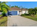 Charming one-story home with a manicured lawn and a blue two-car garage door at 43 Pergola Pl, Ormond Beach, FL 32174