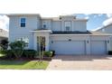 Charming two-story home featuring a three-car garage, a well-manicured lawn, and a brick paved driveway at 5030 Tibet Ct, St Cloud, FL 34772