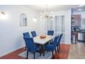 Dining room featuring wood floors, a modern light fixture, and blue velvet chairs at 5521 Rutherford Pl, Oviedo, FL 32765