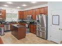 Modern kitchen features stainless steel appliances, granite countertops, and tiled flooring at 5521 Rutherford Pl, Oviedo, FL 32765