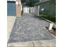 Paver driveway leading to the side of the home with a white fence at 7214 Rex Hill Trl, Orlando, FL 32818