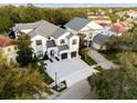 Aerial view of a beautiful two-story home, showcasing lush landscaping and a paver driveway at 7465 Gathering Loop, Reunion, FL 34747