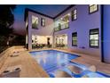 Inviting backyard pool area with submerged lounge chairs and an outdoor kitchen at 7465 Gathering Loop, Reunion, FL 34747