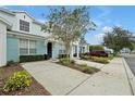 View of townhouse showcasing blue exterior, individual parking spots, and tidy landscaping at 7671 Otterspool St, Kissimmee, FL 34747