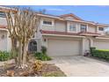 Inviting townhome with a two-car garage, lush landscaping, and gated front courtyard at 7709 Sundial Ln, Orlando, FL 32819