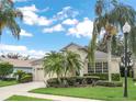 Single-story home with landscaped front yard, a two-car garage, and a bright sky at 8044 Saint James Way, Mount Dora, FL 32757