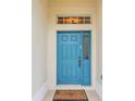 Inviting blue front door with sidelight and transom window, and a welcome mat at 8044 Saint James Way, Mount Dora, FL 32757