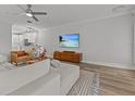 Comfortable living room adjacent to kitchen, showcasing hardwood floors and a mounted flat screen TV at 945 N Fern Creek Ave, Orlando, FL 32803