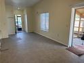 Bright living room featuring neutral paint, tiled flooring, and a sliding glass door at 1002 Stucki Ter, Winter Garden, FL 34787