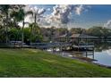 Lush green backyard that leads to a wooden dock and covered boat lift on the lake at 1100 S Lake Sybelia Dr, Maitland, FL 32751