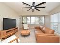 Bright living room with a large ceiling fan, light wood floors, and modern furniture arrangement at 117 Shannon Dr, Sanford, FL 32773