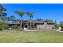 Charming brick home with manicured lawn, palm trees, and inviting screened-in entryway at 1303 Sultan Cir, Chuluota, FL 32766