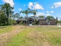Charming brick home with a large front lawn, palm trees, and meticulously kept garden beds at 1303 Sultan Cir, Chuluota, FL 32766