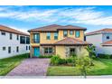 Charming two-story home with a tile roof, stone accents, manicured lawn and a brick driveway at 13169 Bromborough Dr, Orlando, FL 32832