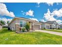 Charming single Gathering home featuring stone accents, neutral paint, manicured lawn and a two car garage at 132 Lake Smart Cir, Winter Haven, FL 33881