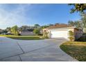 Wide driveway leading to a spacious two-car garage, framed by a well-maintained lawn and mature trees at 13330 Meergate Cir, Orlando, FL 32837