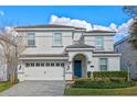 Charming two-story home with a well-manicured lawn and a striking blue front door at 1585 Plunker, Davenport, FL 33896