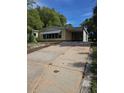 Charming single-story home with a covered carport and an expansive concrete driveway at 1765 W Schwartz Blvd, Lady Lake, FL 32159