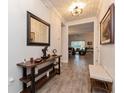 Inviting hallway featuring wood-look tile flooring and a stylish console table with decor at 1908 Perch Hammock Loop, Groveland, FL 34736