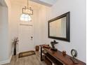 Entryway with wood look floors, modern light fixture, and elegant wood table with decor at 1908 Perch Hammock Loop, Groveland, FL 34736