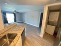 View from kitchen into the living room and laundry with wood-look tile flooring at 1932 Lake Atriums Cir # 77, Orlando, FL 32839