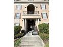 Building entrance with staircase, columns, and manicured landscaping at 2013 Tizewell Cir # 1408, Orlando, FL 32837