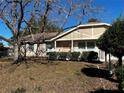 A charming home with a manicured lawn, accented by a picket fence and a mature shade tree at 26 Palm Run, Ocala, FL 34472