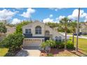 Two-story home with a 2-car garage, palm trees, and mature landscaping on a sunny day at 2806 Baywood Ln, Kissimmee, FL 34746