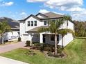 Stunning home featuring a brick driveway, green lawn, and tropical palm tree at 3245 Upland Pt, Oviedo, FL 32765