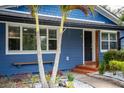 Inviting front entrance with a quaint bench, lush landscaping, and vibrant blue exterior paint at 328 Lake Fair Ln, Winter Park, FL 32789