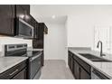 Modern kitchen showcasing granite countertops, stainless steel appliances, and dark wood cabinetry at 399 Sequoia Dr, Lake Wales, FL 33859