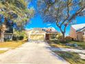 Charming yellow home with red front door, dormer windows, mature trees and a two-car garage at 4331 Willowcrest Ct, Orlando, FL 32826