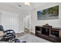 A view of the bedroom, featuring luxury vinyl flooring, a comfortable chair, and an entertainment center at 6132 Saint Julian Dr, Sanford, FL 32771