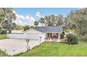 Charming single-story home featuring a well-manicured lawn, picket fence, and attached garage at 632 Tranquil Oaks Ln, Oviedo, FL 32765