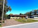 Quaint single-story home with a well-kept lawn and mature trees on a sunny day at 702 Apricot Dr, Ocoee, FL 34761